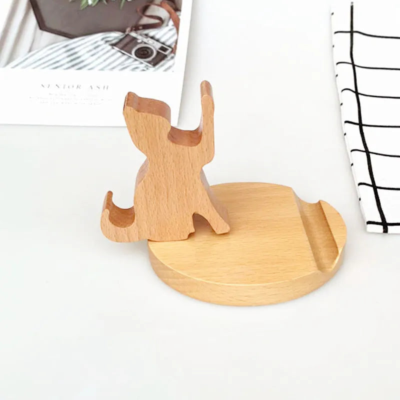 Solid beech wood phone holder with resin puppy decoration and a pound coin in the integrated slot.