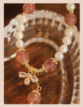 Handmade women's strawberry quartz crystal bracelet with a decorative bow clasp.