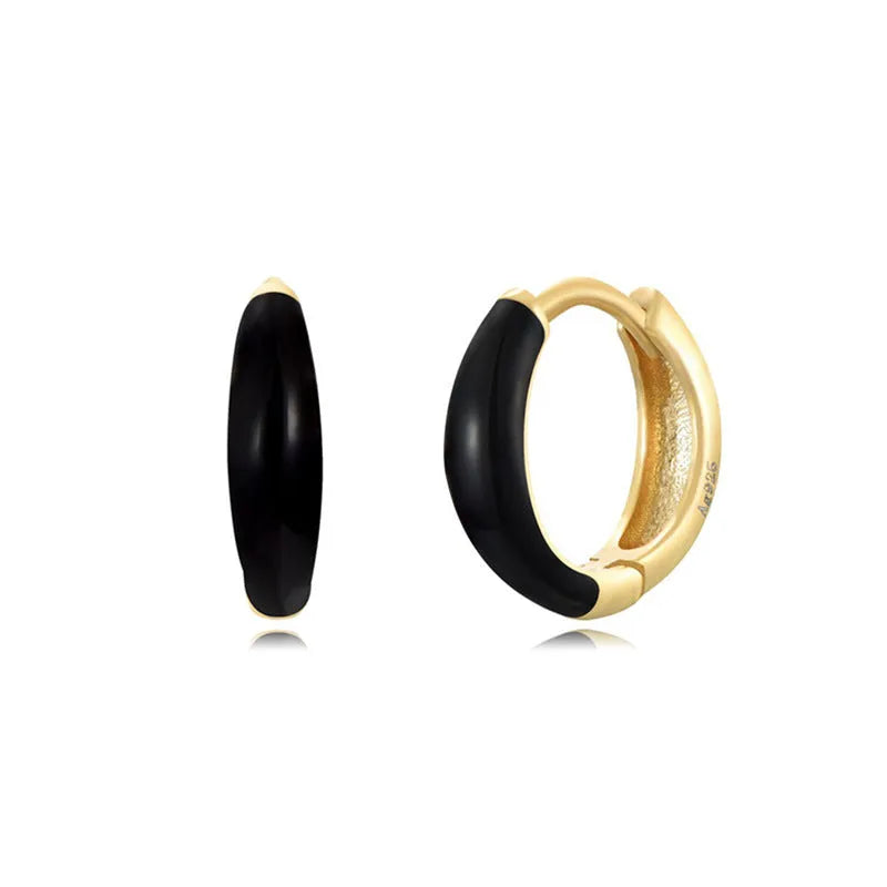 A pair of glossy light green epoxy oval earrings with a U-shaped curve and silver-coloured post on a grey background.