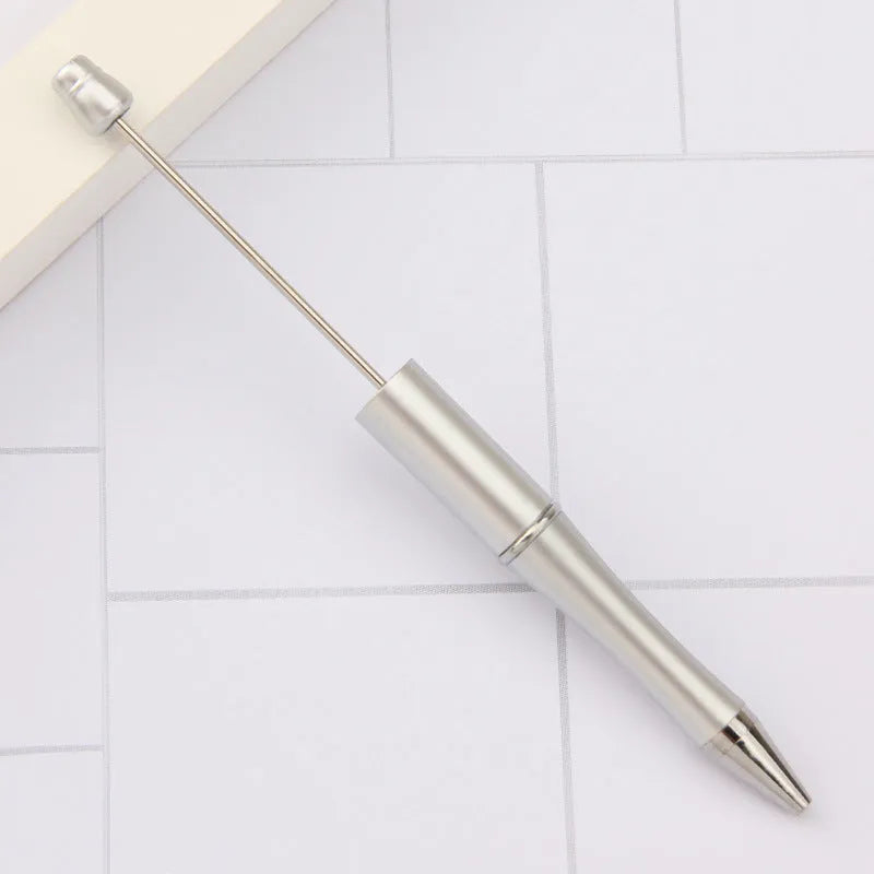 Colourful spinning ballpoint pen with plastic beads on a white background.