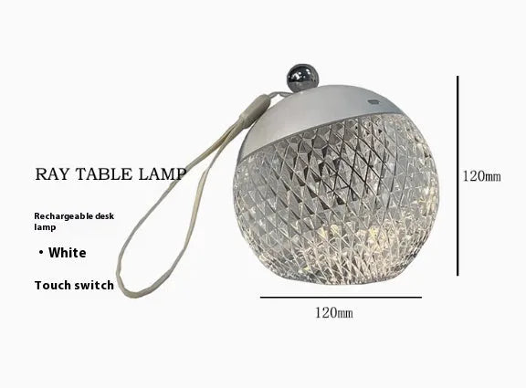Small portable dimmable night lamp in chrome finish on wooden bedside table