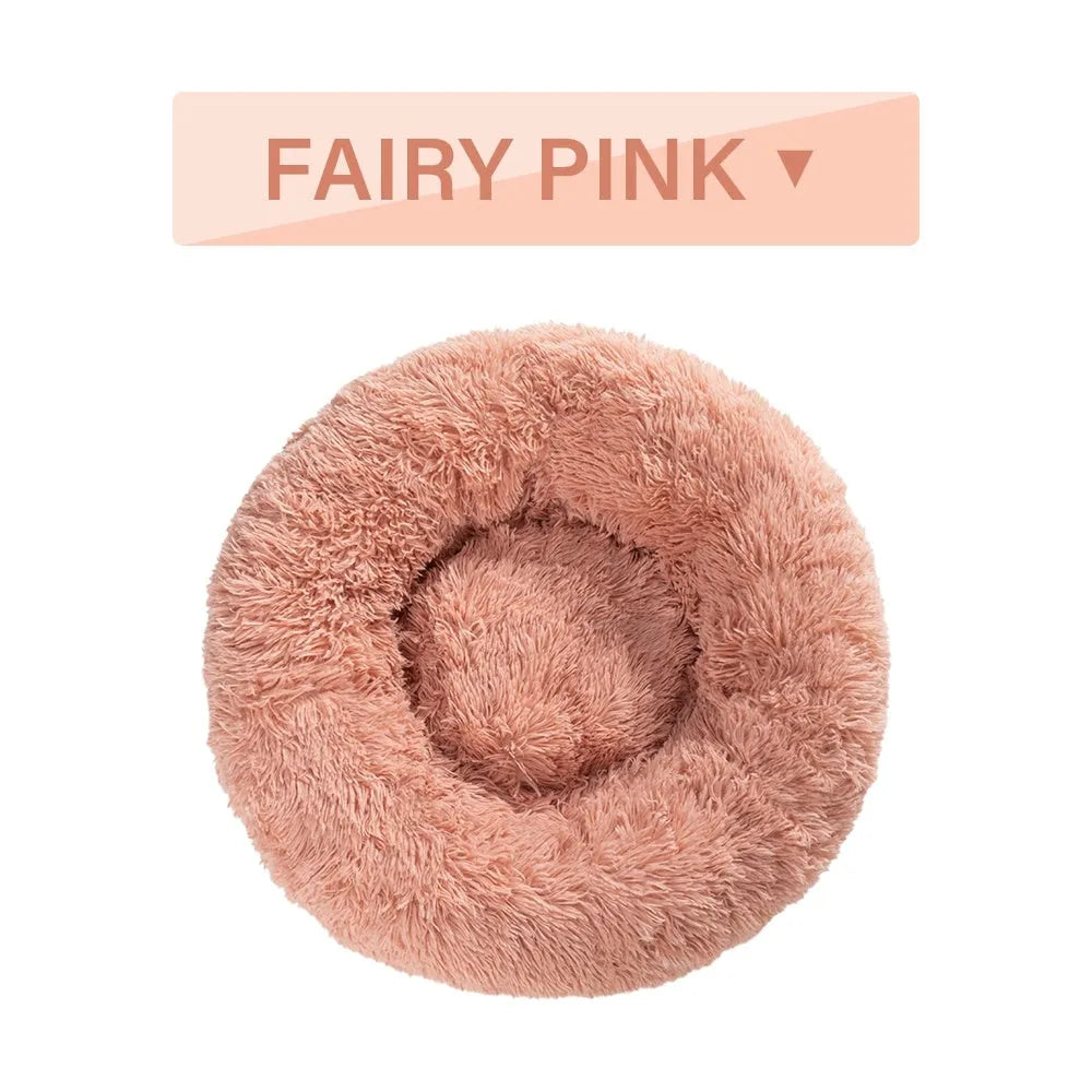 A fluffy, round donut-shaped dog bed with a raised rim in long plush fabric.