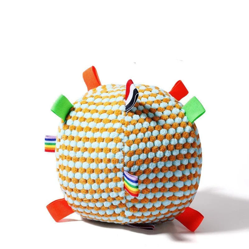 Blue hollow plastic dog ball with pineapple lattice pattern and rattle inside on grass