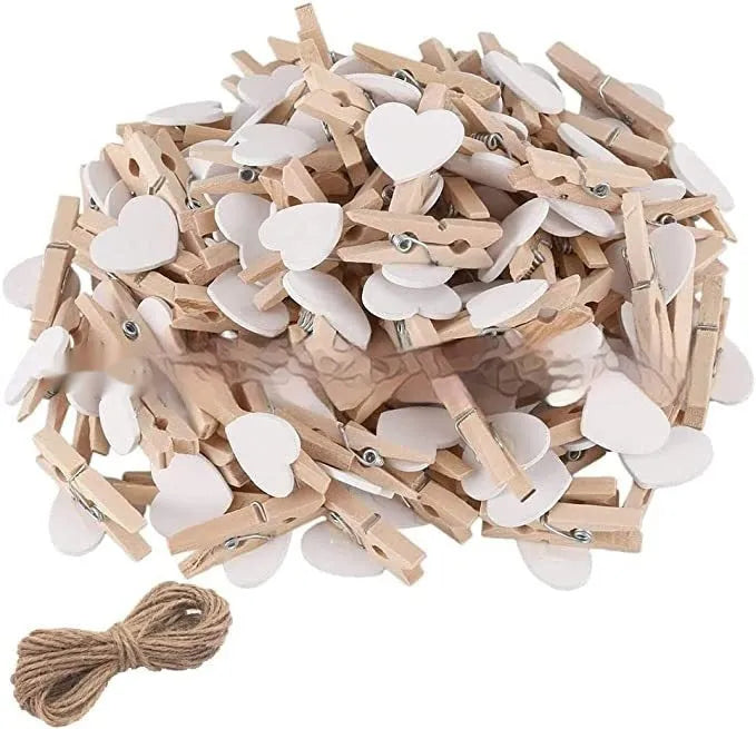 Set of five handmade solid wood heart-shaped clips in assorted colours on a wooden surface.