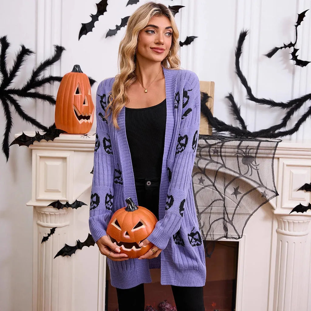 Women's black cardigan with orange pumpkin head jacquard knit pattern, shown as a medium-length coat.