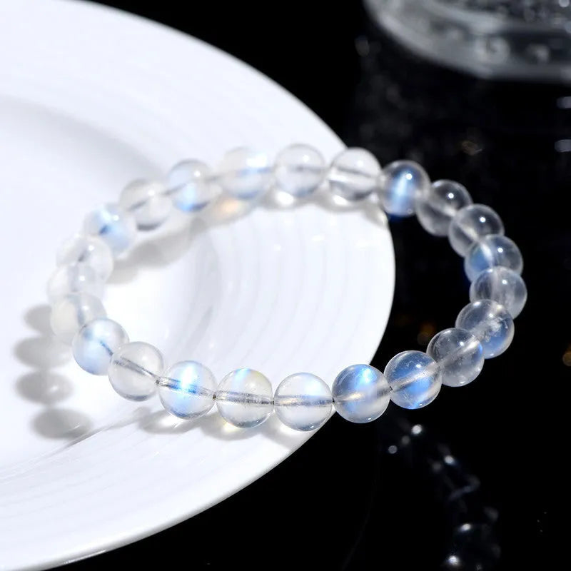 Natural cream coloured Blue Moonlight crystal bracelet on a wrist, showing minimalist unisex design.