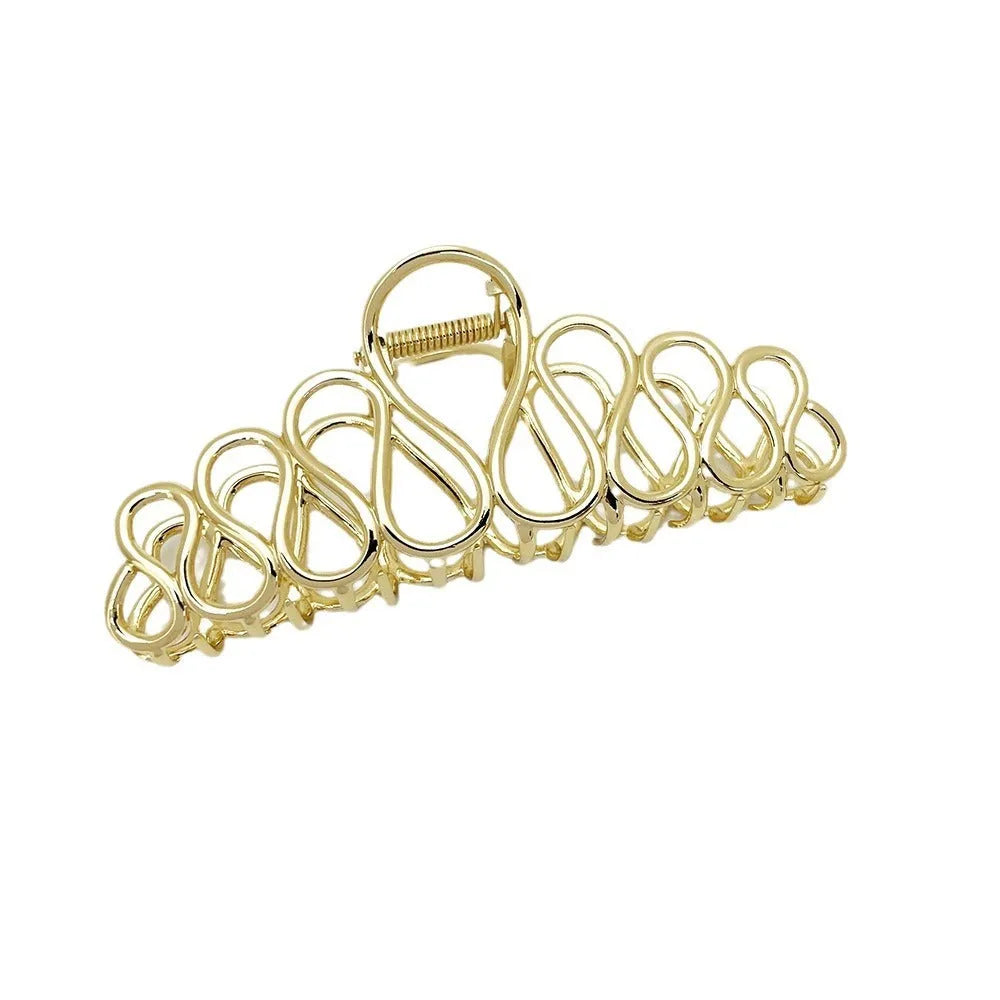 Minimalist large hair clip with gold electroplated finish and tassel detail on irregular geometric alloy design