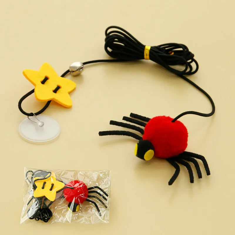 Cat toy with elastic rope hanging over a door, featuring a feather wand, jingle bell, and dangling spider attachment.
