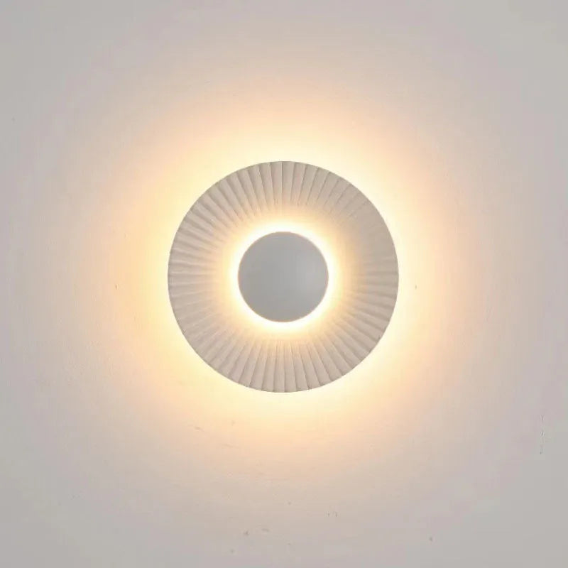 Round aluminium wall lamp with LED light in a white and gold colour option.