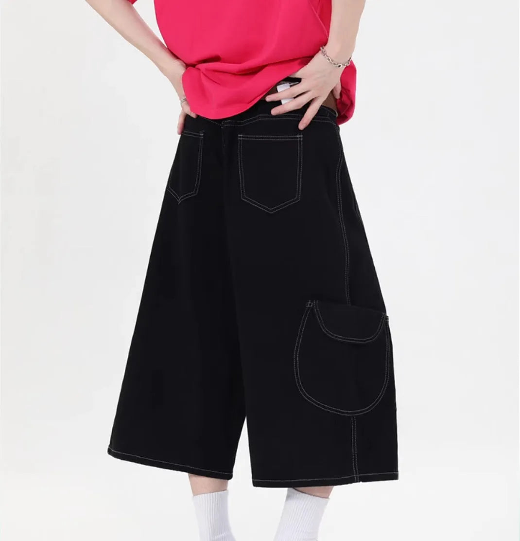Men's red denim wide-leg cropped workwear shorts with multiple pockets on a mid waist