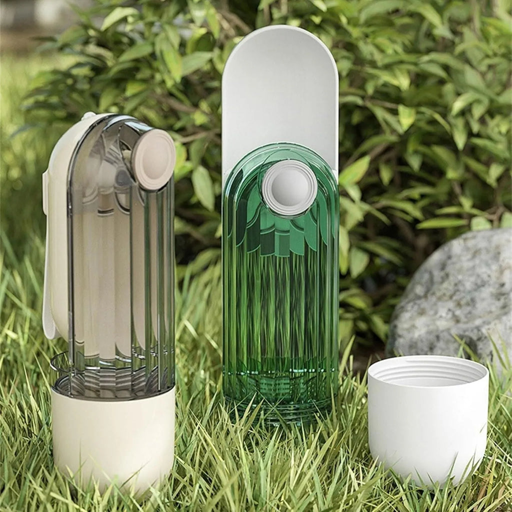 Beige and green foldable dog water bottle with food container, showing scale next to a dog's muzzle.