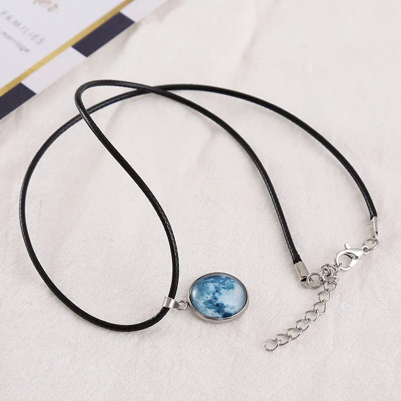 Luminous moon and star constellation pendant necklace with a silver-tone chain on a black background.