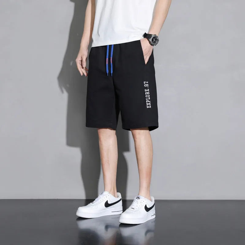 Boys' loose-fitting cotton summer shorts in black, shown on a hanger.