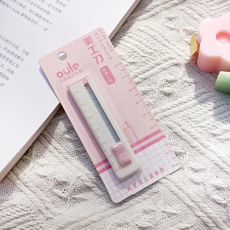 Small plastic-blade art knife in blue, pink, purple, orange, and khaki colours.