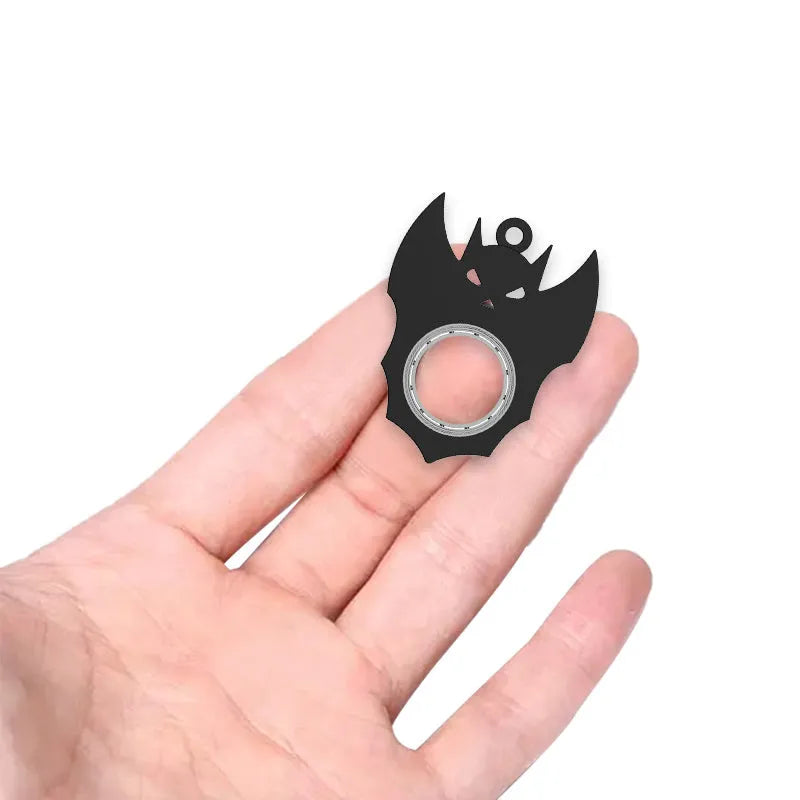 Black plastic Halloween bat demon ghost fidget spinner keychain with bottle opener on a dark background