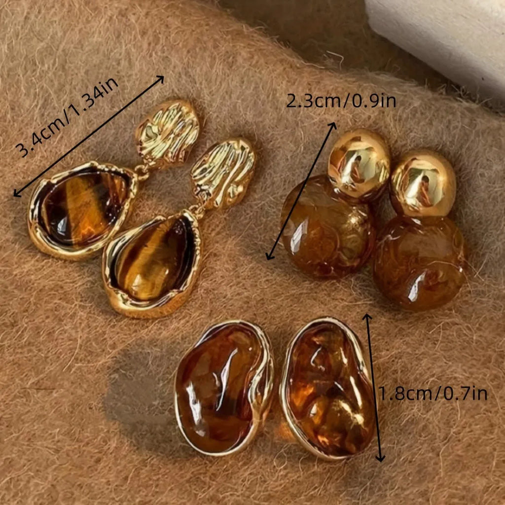 Set of three pairs of geometric alloy holiday ear studs with tassels in different styles.