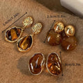 Set of three pairs of geometric alloy holiday ear studs with tassels in different styles.