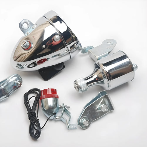 Silver bicycle dynamo generator light kit mounted on a bike fork, with wires for headlight and tail light connections.