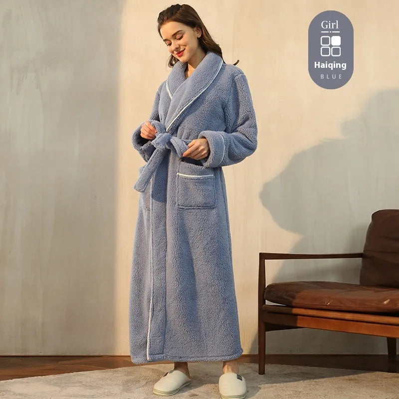 A man and woman wearing matching navy blue thick flannel bathrobes, showcasing the wrap-around design and plush fabric.