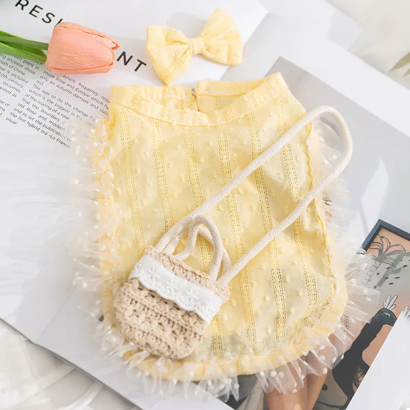 Two-tone sleeveless pet outfit in yellow or blue with ruffles, matching bow and small woven crossbody bag.