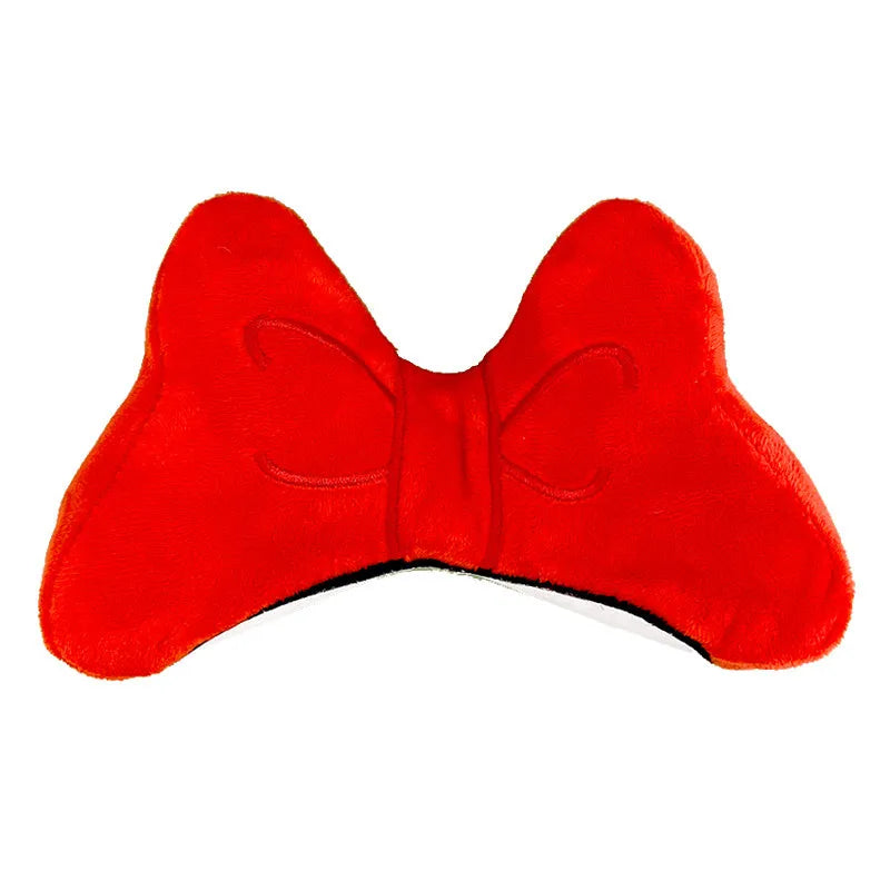 Soft red plush bow tie decoration for helmet customisation, shown against a helmet shell.