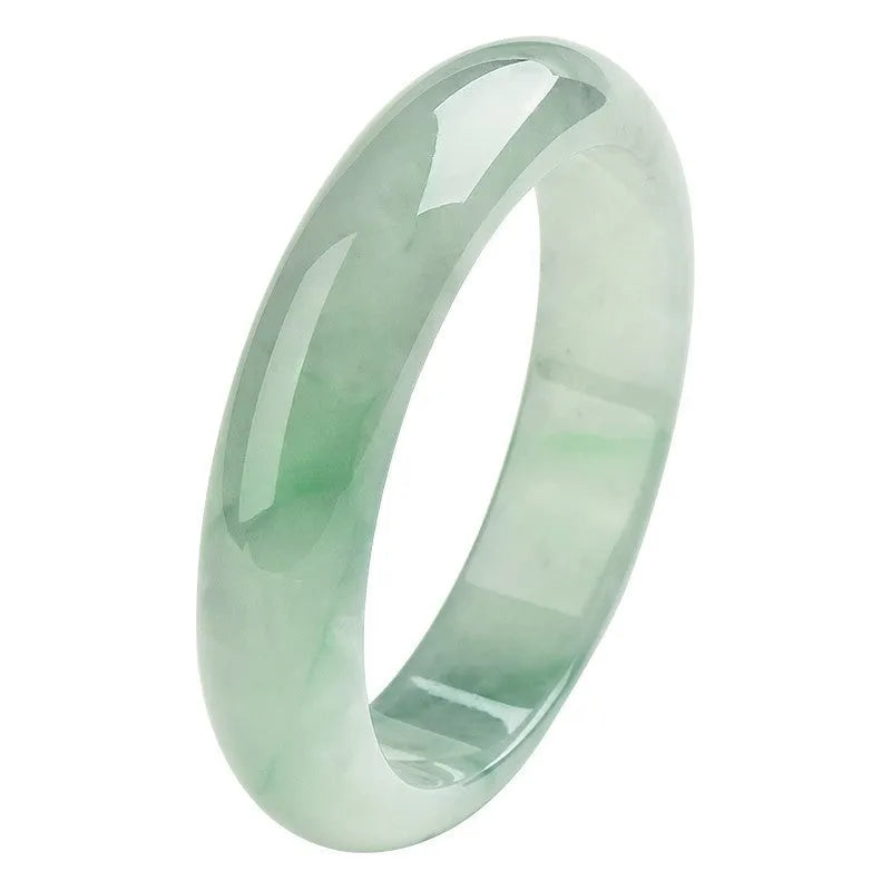 Light green jade bracelet on a wrist, showing its natural stone texture and colour.