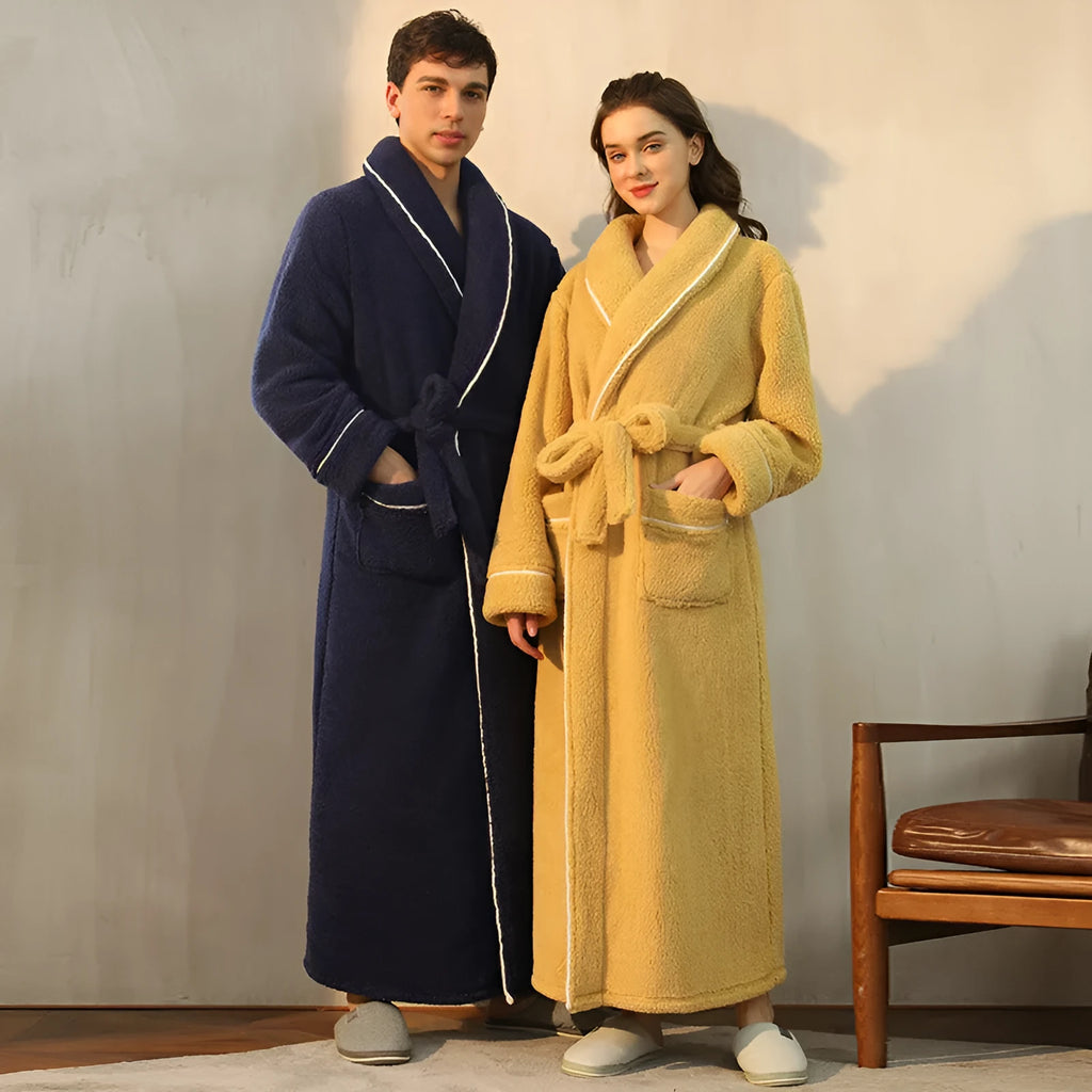 A man and woman wearing matching navy blue thick flannel bathrobes, showcasing the wrap-around design and plush fabric.