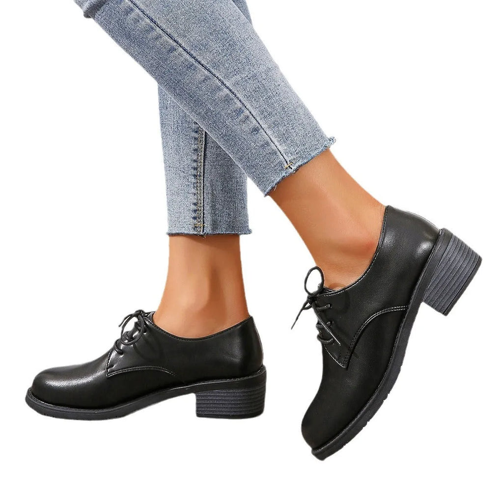 Black women's low-top work shoes with a chunky mid heel and rubber sole.