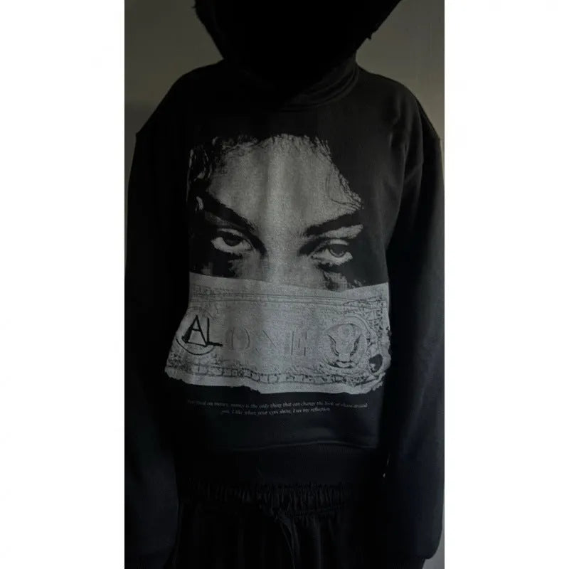 Black women's loose-fit hoodie with a cartoon print, shown in a casual setting.