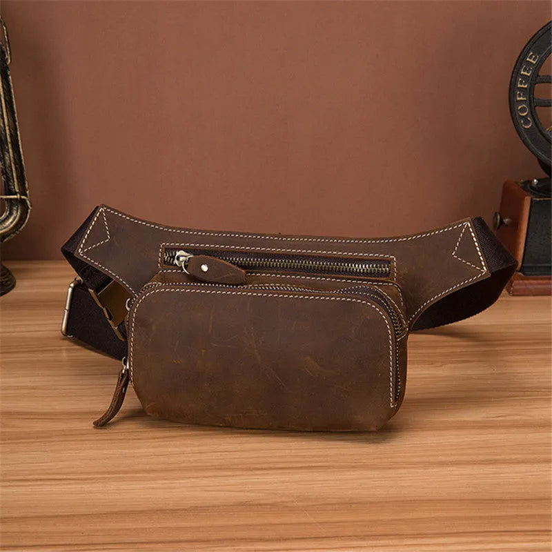 Brown top-grain cowhide men's sports waist bag with pull-cord closure, shown with a 10-inch laptop.