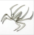 Three-dimensional metal spider bumper sticker in gold colour on vehicle surface