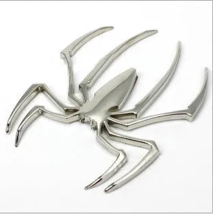 Three-dimensional metal spider bumper sticker in gold colour on vehicle surface