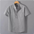 Man wearing a beige short sleeve linen and slub cotton casual shirt with a stand collar.