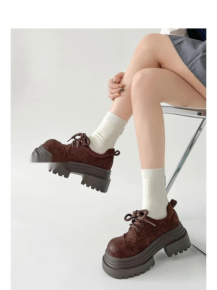 Retro British style loafers in solid colour with round toe and low muffin heel on a plain background