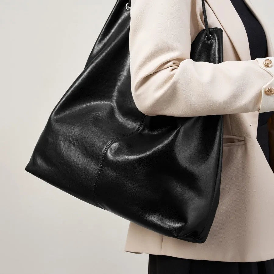 Brown genuine leather tote bag with contrast stitching and large capacity, front view on white background