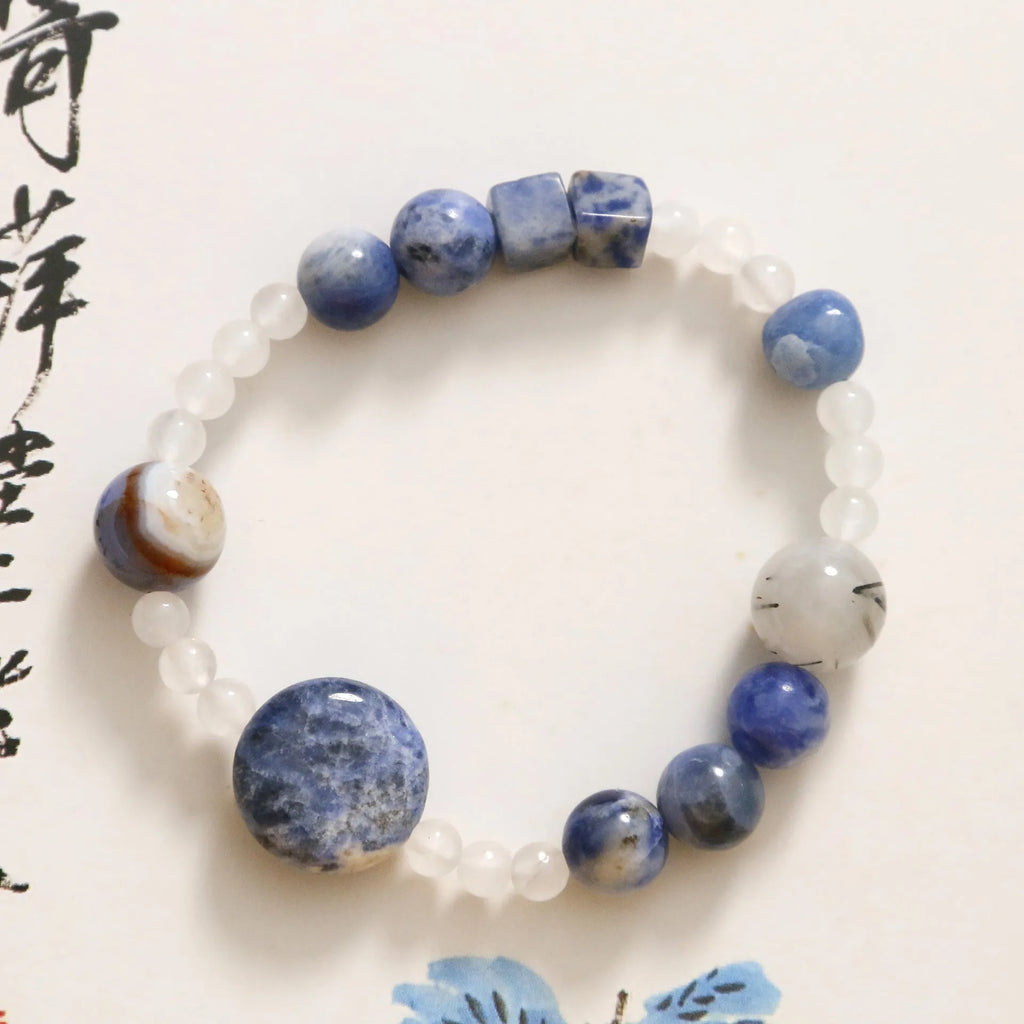Hand-woven unisex bracelet with blue point stone and black hair crystal agate in a geometric design.