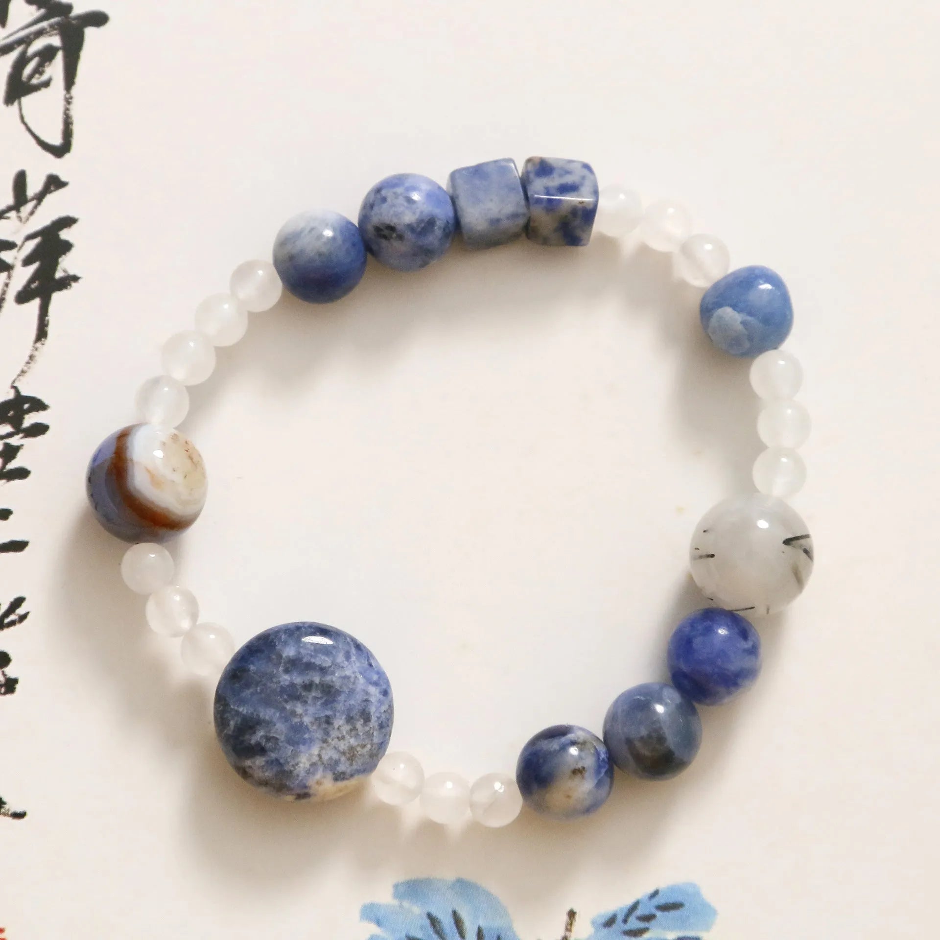 Hand-woven unisex bracelet with blue point stone and black hair crystal agate in a geometric design.