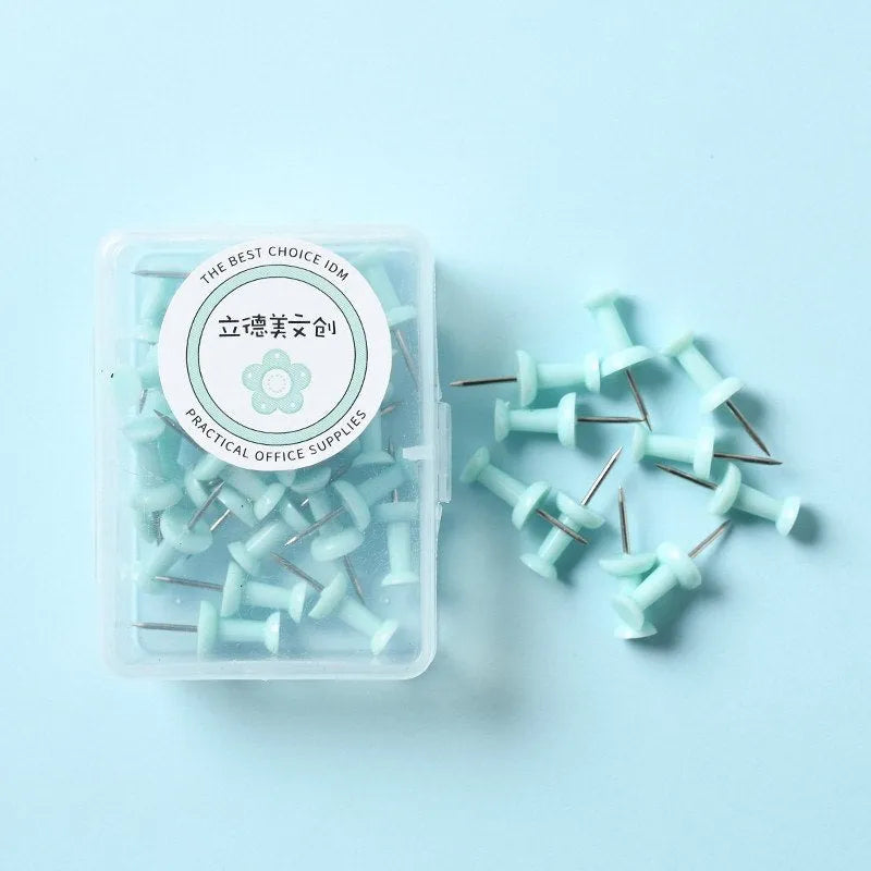 Plastic push pins in cherry blossom pink, mint green, and lavender, showing large and small sizes on a corkboard