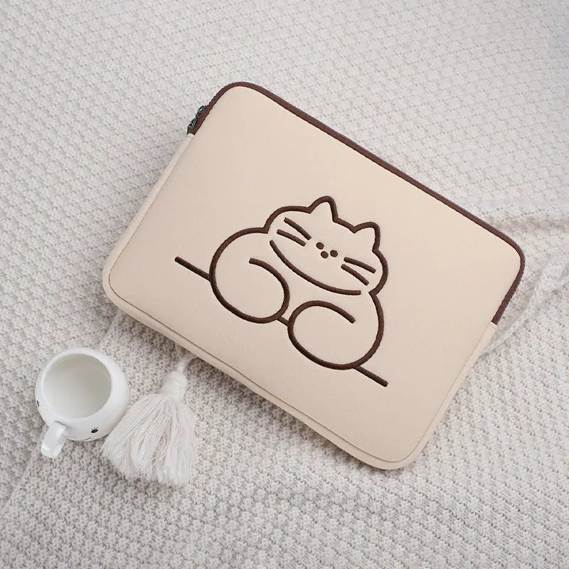 Embroidered animal design laptop sleeve in polyester, shown next to a laptop.