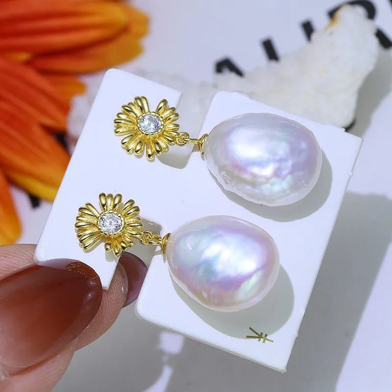 A pair of Baroque-style floral earring frames made of sterling silver, featuring a small integrated ring holder, presented without pearls.
