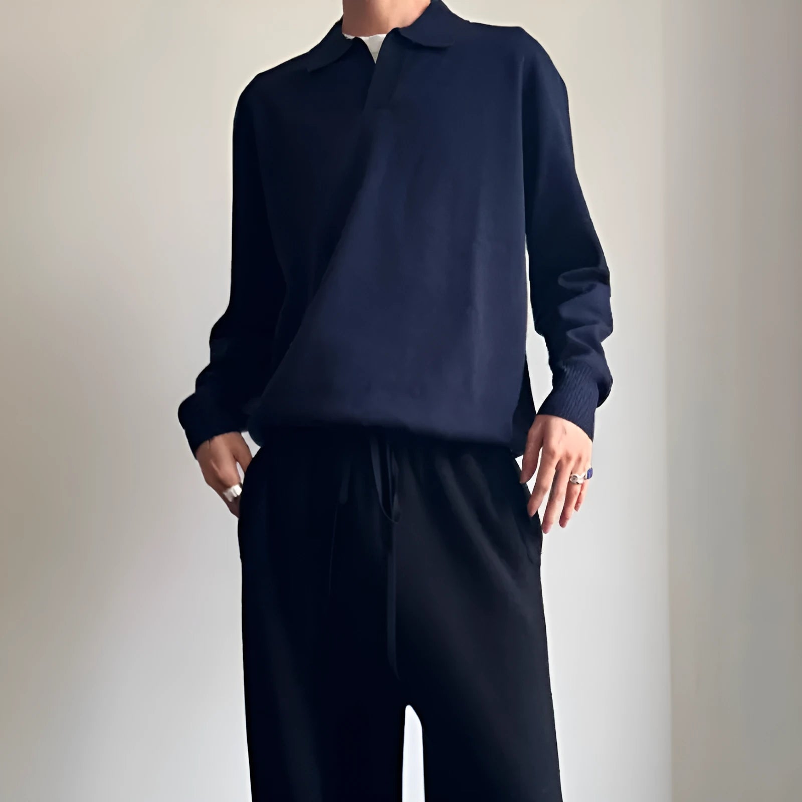 Man's milky white pure wool polo sweater with a lapel collar, shown in a loose fit.