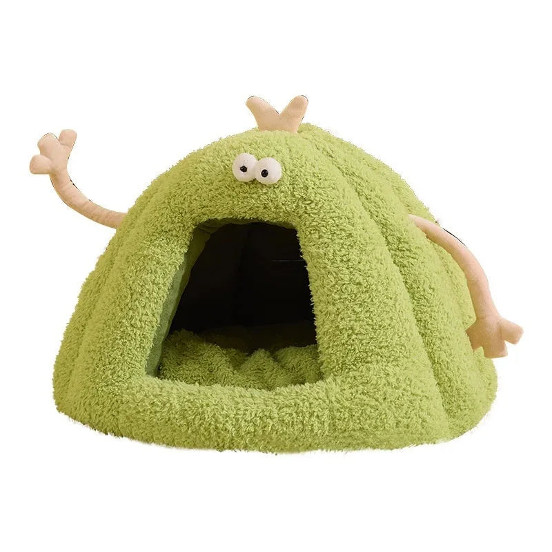 Green monster-shaped semi-enclosed cat kennel bed for small cats on a floor.