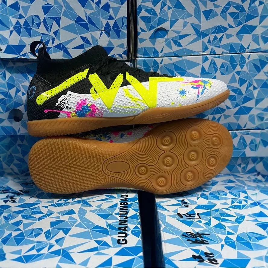 Low-top black and yellow football trainers with a spiked rubber sole and mesh detail.