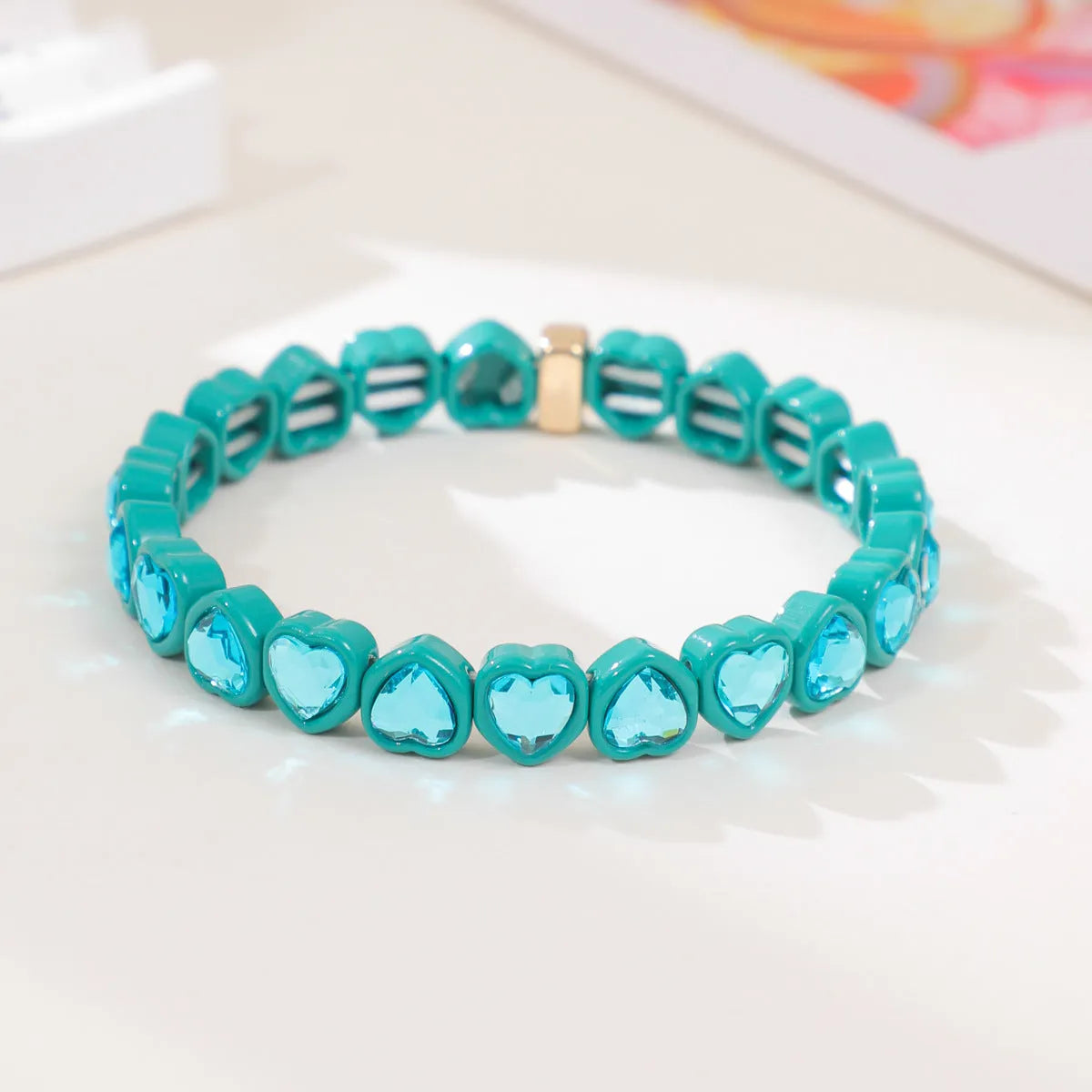 Rainbow enamel heart charm bracelet on alloy base with diamond treatment, stretch band, multicolour design.