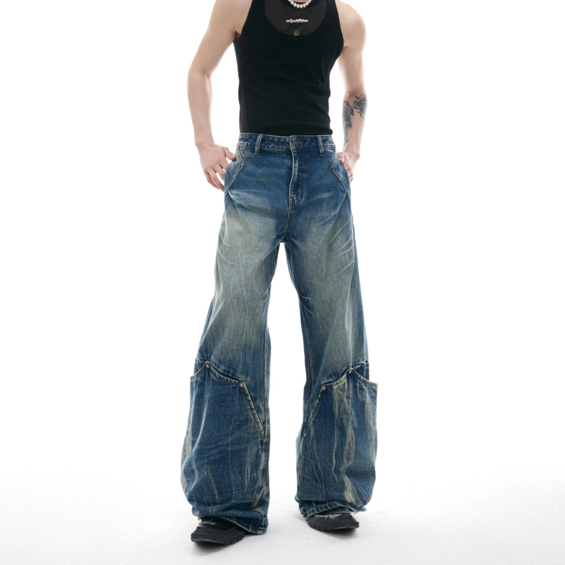 Man wearing Verdant Blue loose fit jeans with a retro washed burst pattern and a curved knife leg silhouette.
