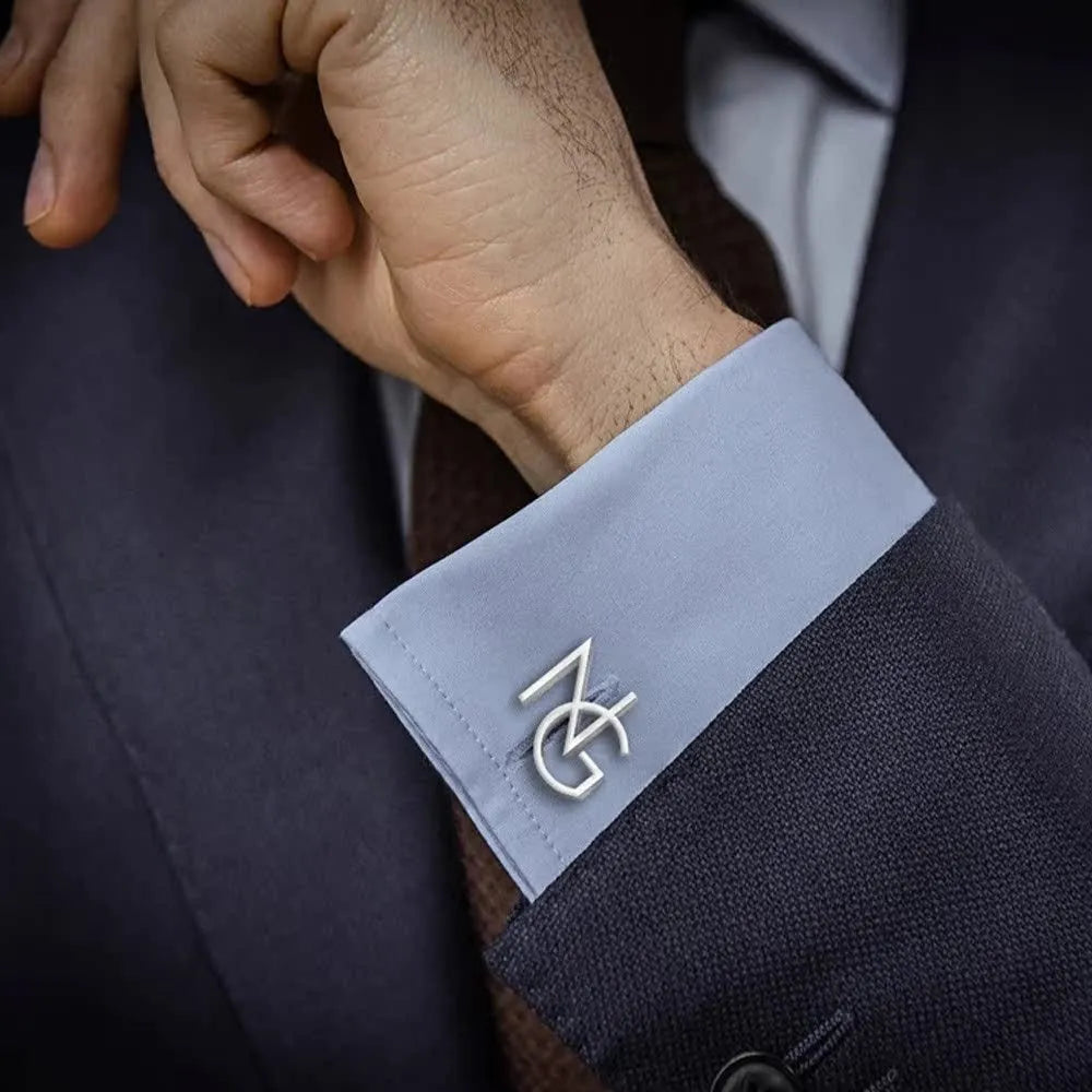 Handmade frosted personalised name abbreviation metal cufflinks in gold colour on a grey background