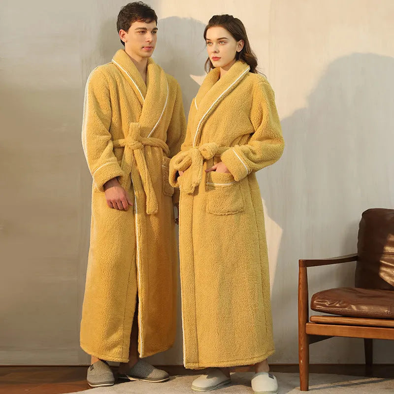A man and woman wearing matching navy blue thick flannel bathrobes, showcasing the wrap-around design and plush fabric.