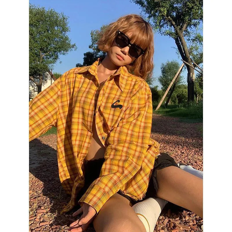 A loose-fit yellow plaid cardigan shirt for men and women, shown on a hanger.