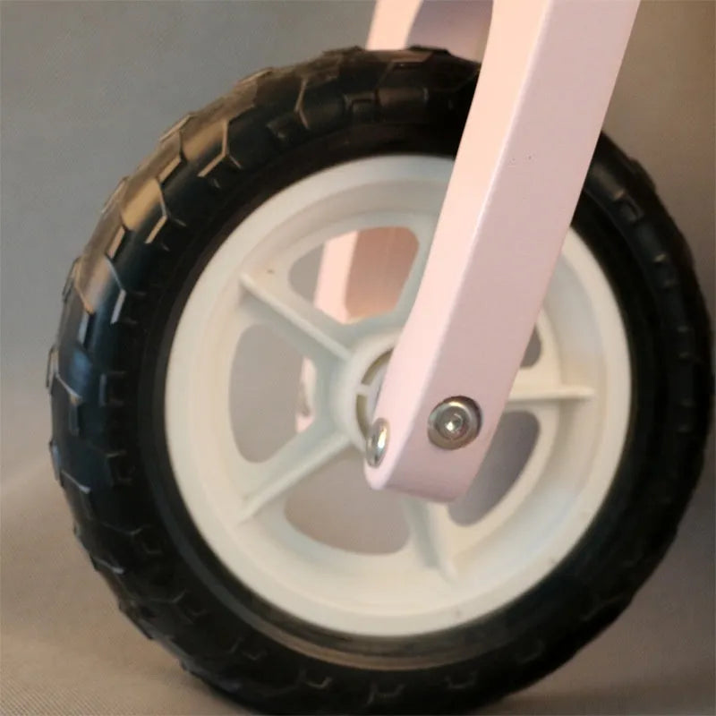 Pink wooden balance scooter for toddlers and children with 10-inch wheels.