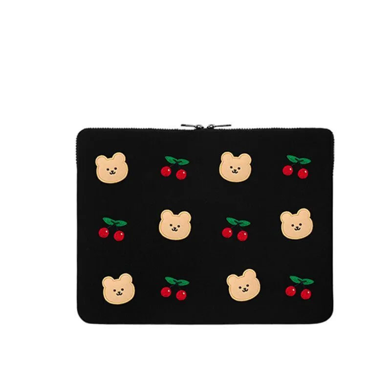 Embroidered animal design laptop sleeve in polyester, shown next to a laptop.